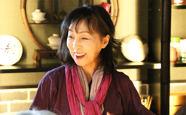 無天茶坊のお茶コーナーで、笑顔で接客する中国茶藝技師の女性